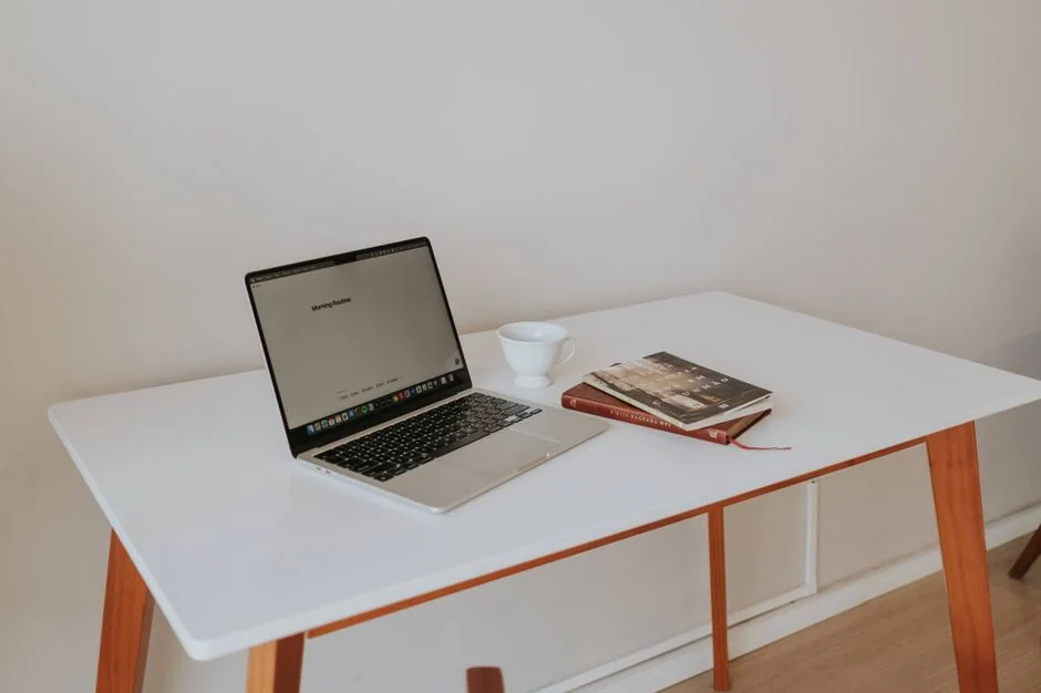 A clean and organized home office desk with a cleaner bottle and sponge, emphasizing simplicity and functionality.